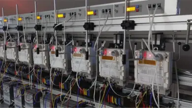 Řada elektroměrů na testovacím stojanu pro ověření bez demontáže.