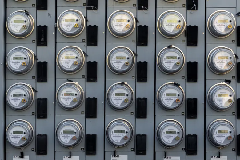 Řada nových digitálních elektroměrů namontovaných na šedé zdi.