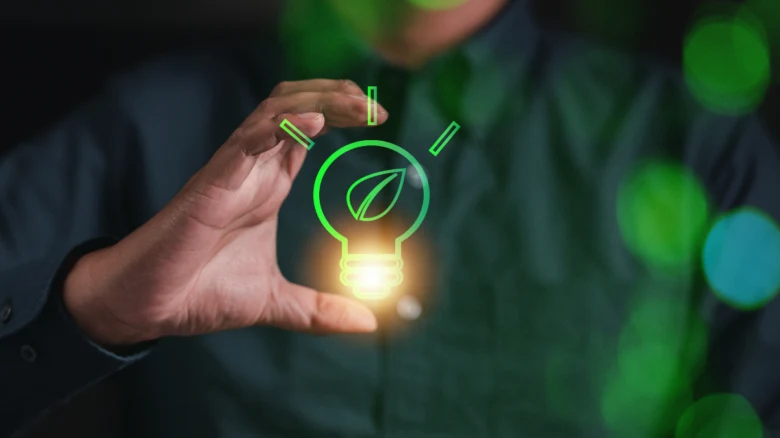 Hand holding lightbulb icon with leaf symbolizing eco-friend