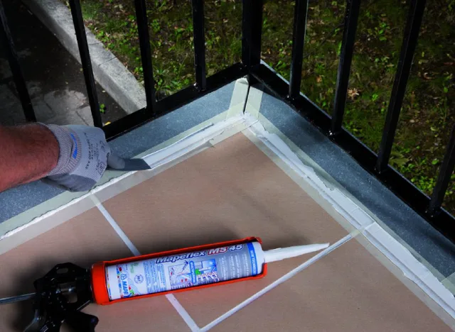 Instalace tmelu do spáry dlažby pomocí pistole na těsnicí hmotu.