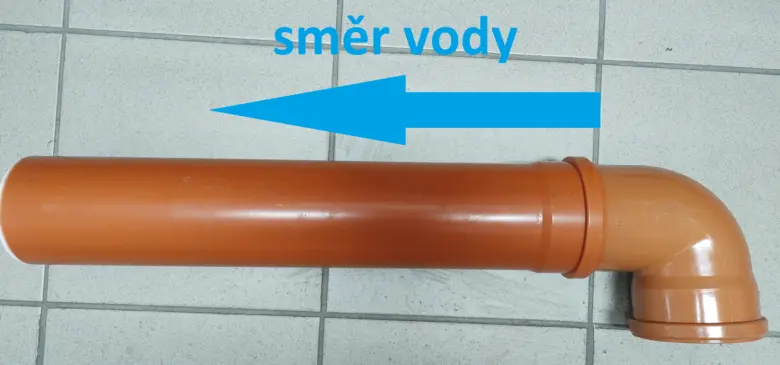 Truba pro dešťovou kanalizaci s označením směru proudění vody.