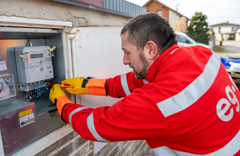 Elektromontér vyměňuje elektroměr v domovním rozvaděči.