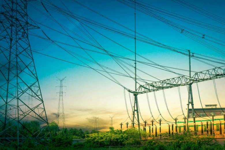Elektrické vedení s vysokým napětím na pozadí zapadajícího slunce.