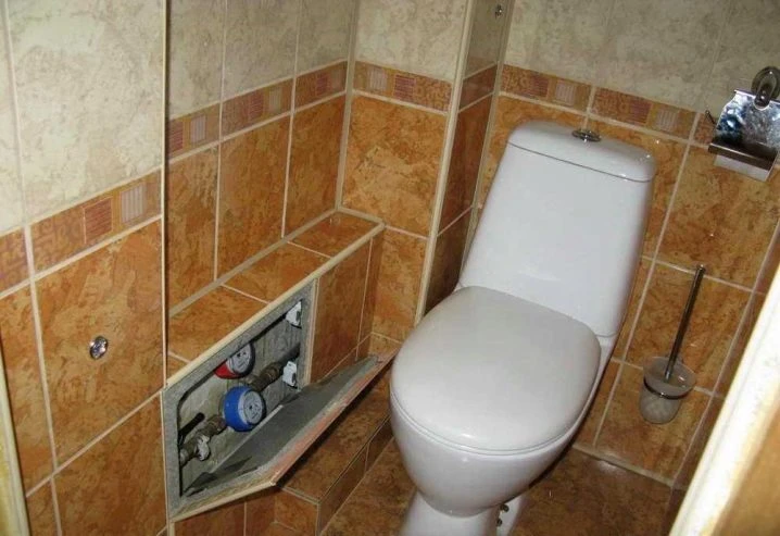 Záchod s přístupem k vodovodním přípojkám v otevřené zdi.