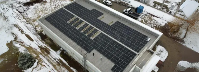 Vzdušný pohled na střechu domu s fotovoltaickými panely.