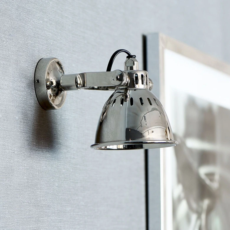Stříbrná nastavitelná stěnová lampa pro čtení v ložnici.