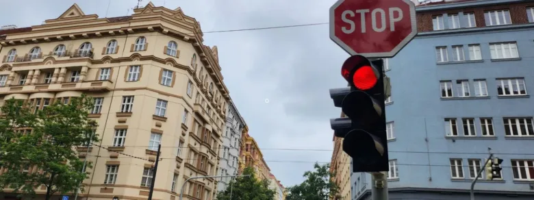 Červený semafor s dopravní značkou STOP na křižovatce.