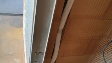 Bílá venkovní jednotka klimatizace s viditelným kabelovým vedením.