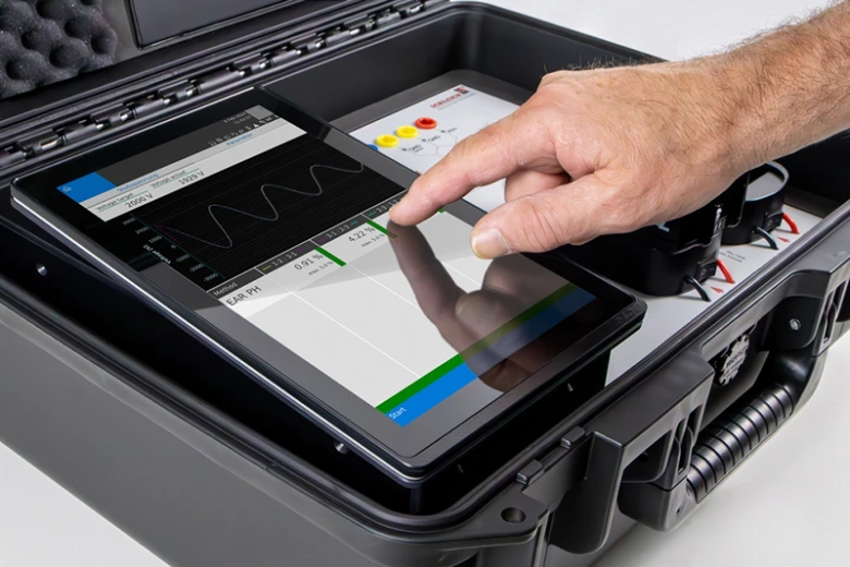 Ruka ovládá tablet pro testování izolace motoru v přípravném kufru.