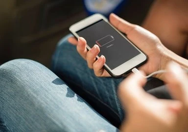 Person holding phone with charger cable