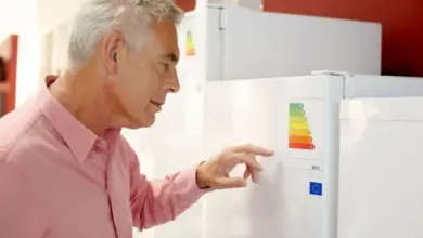 Muž kontroluje energetickou třídu lednice v obchodě.