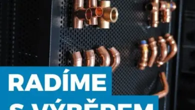 Zlaté měděné trubky a spojky na černém pozadí.
