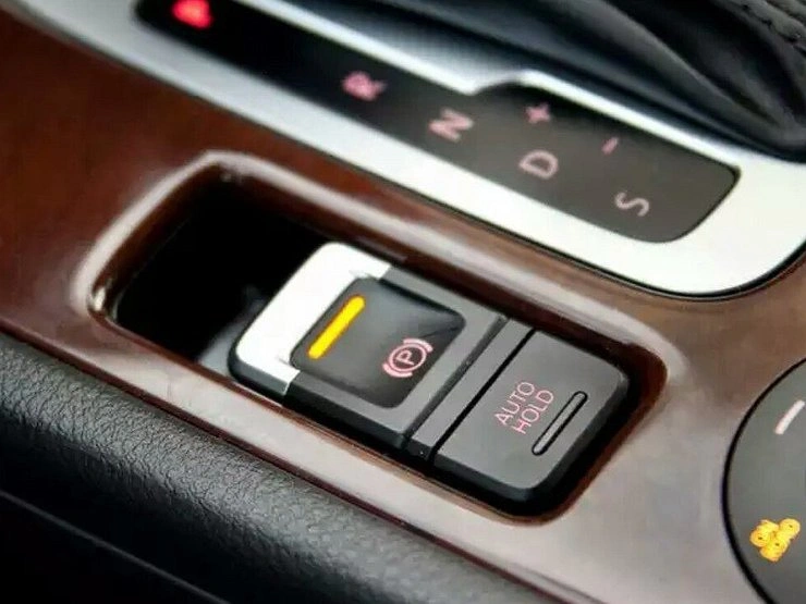 Tlačítko elektrické parkovací brzdy s funkcí AUTO HOLD v interiéru automobilu.