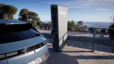 Elektromobil nabíjen na veřejné stanici s výhledem do krajiny.