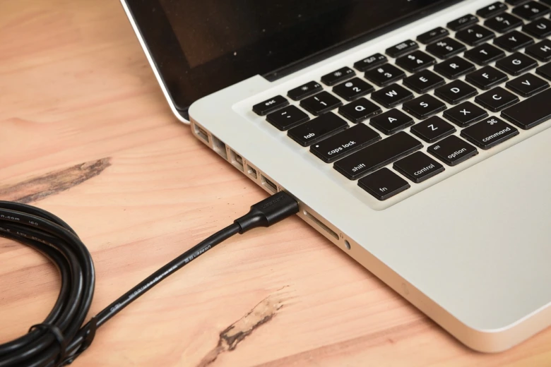 Laptop připojený síťovým kabelem LAN pro sdílení souborů.