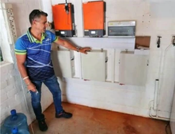 Muž ukazuje na elektrické skříně v interiéru.