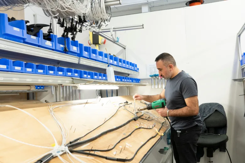 Muž používá tepelnou pistoli k smršťování kabelových bužírek.