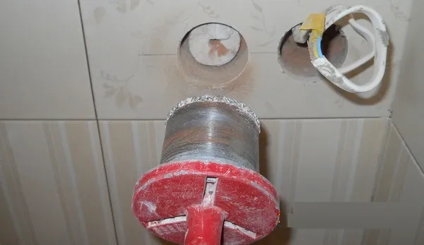 Vrták v zdi pro instalaci zásuvky pračky nebo sušičky