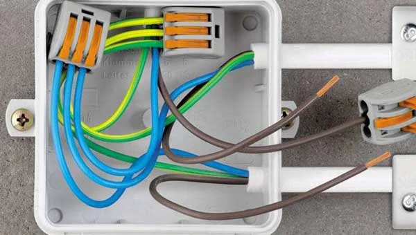 Bílá krabička s vodiči připojenými ke svorkovnicím