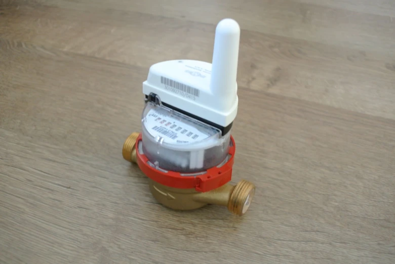 Moderní vodoměr s bezdrátovým modulem na dřevěné podlaze.
