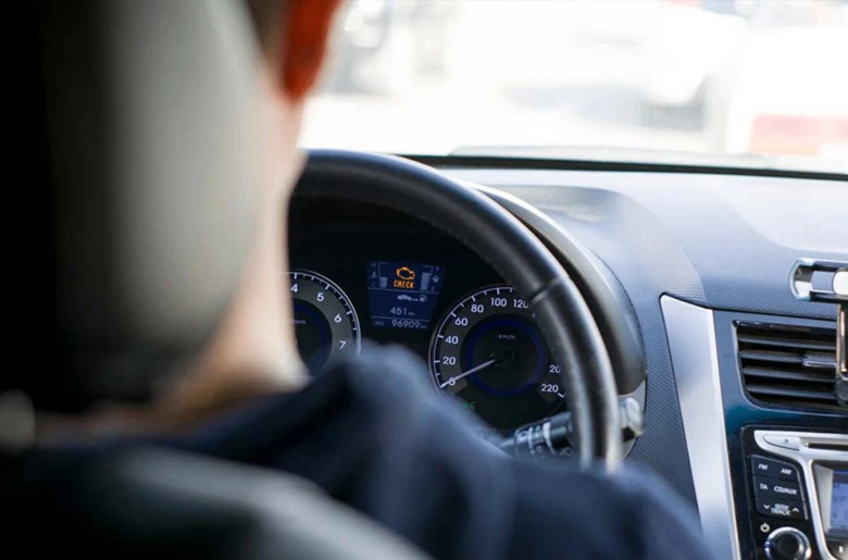 Rozsvícená kontrolka motoru na přístrojové desce auta.