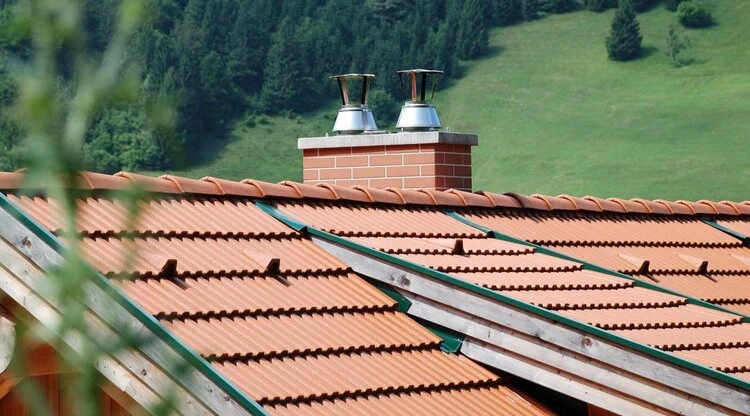 Kamín na střeše s výfukovými ventilátory v přírodním prostředí.