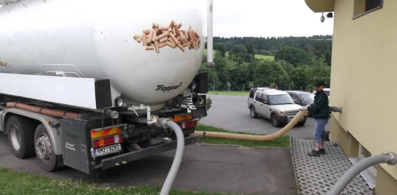 Nákladní vůz s peletami přivádí palivo do skladovacího systému budovy.