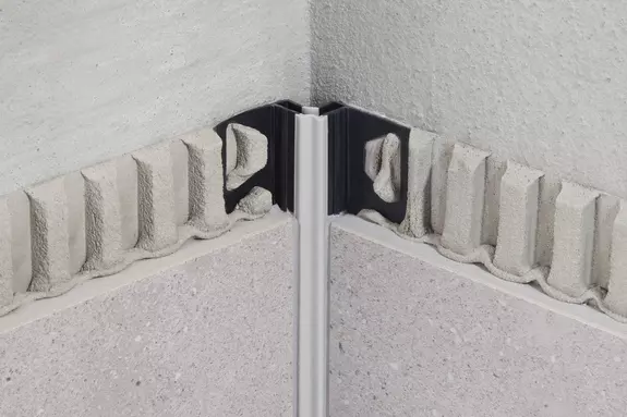 Detail rohové lišty v koupelně s dekorativním omítkovým prvkem.