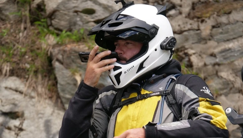 Motocyklista s integrovaným audio-video interkomem v helmetu