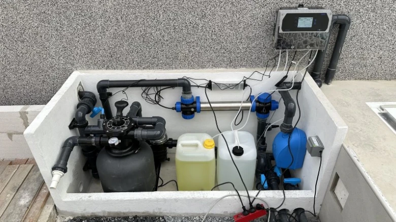 Systém pro filtraci vody v bazénu s čerpadly a chemikáliemi.