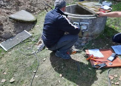 Muž čistí vodu ve studni pomocí nástrojů na trávníku.