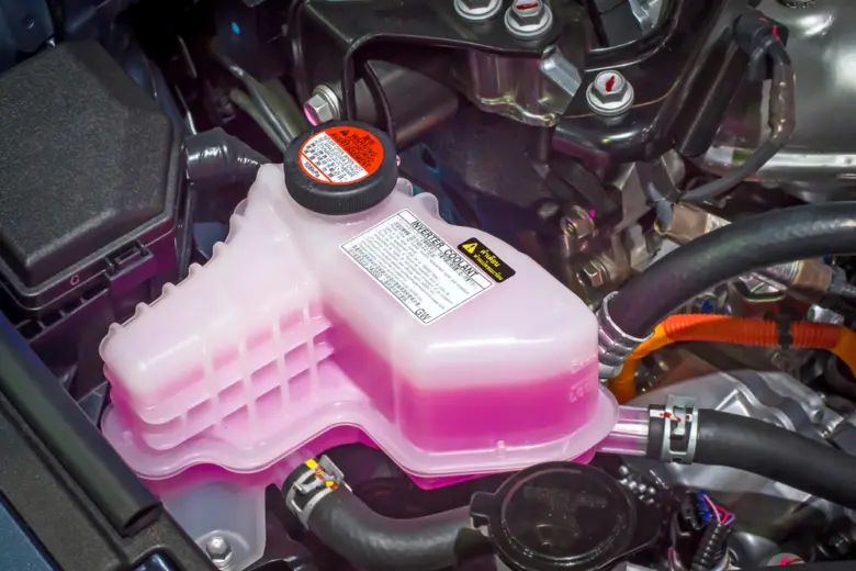 Expanzní nádrž s růžovou nemrznoucí směsí v motoru.