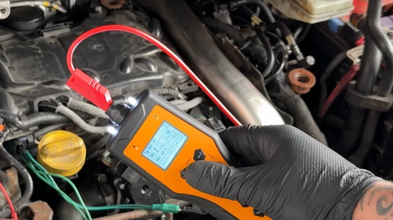 Digitální měřič tlaku paliva připojený k motoru pro diagnostiku.