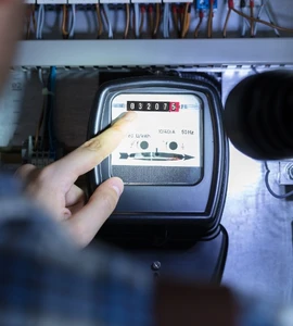 Ruka ukazuje na elektroměr při určování fáze.