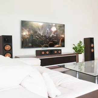 Moderní obývací pokoj s televizorem, zvukovou lištou a reproduktory.