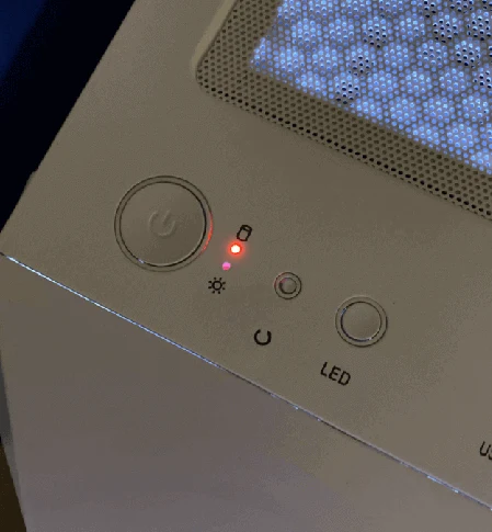Bílý přístroj s červenou LED indikátorem nabíjení baterie.