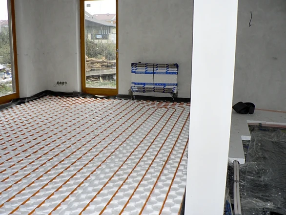 Instalace podlahového vytápění s rozvodem potrubí v novostavbě.