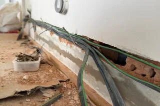 Odkryté elektrické kabely v kuchyni během rekonstrukce podlahy.