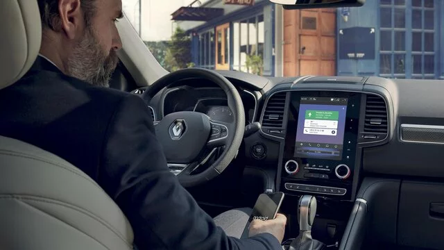 Muž v autě s displejem R-Link pro navigaci