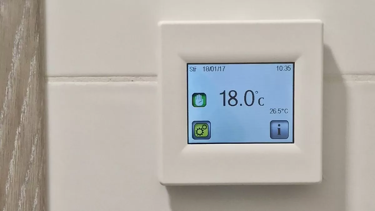 Digitální termostat na zdi ukazující teplotu v místnosti.