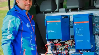 Muž s vybavením pro nabíjení baterií v kufru auta