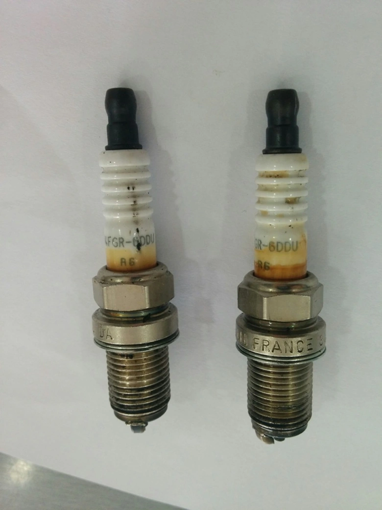 Dvě zapalovací svíčky s různou mezerou a stavem elektrod pro motor.