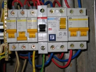 Bílé jističe s připojenými vodiči v elektrickém rozvaděči.