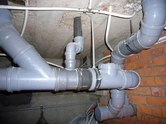 Instalace šedých plastových kanalizačních trubek s přípojkami.